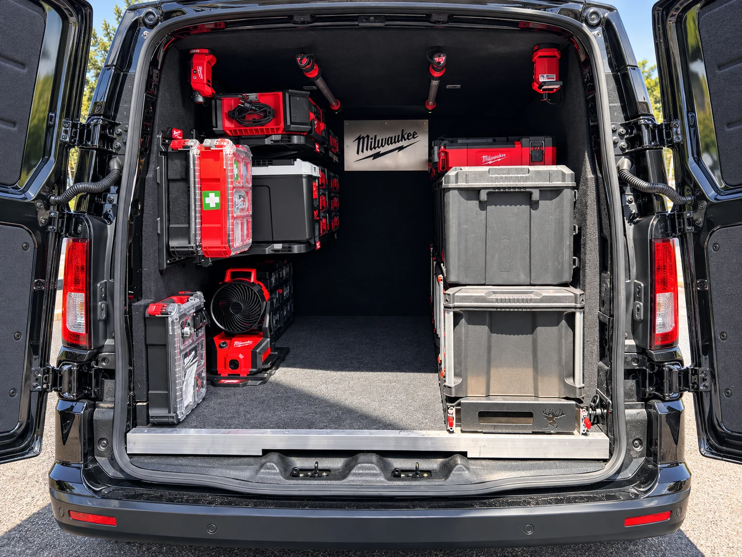 Intérieur du van Milwaukee : caisses PACKOUT arrimées sur les parois et le plateau